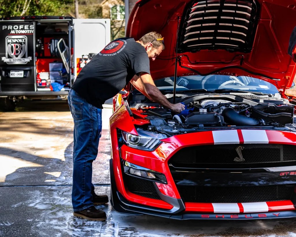 Bespoke Auto Pros technician detailing the engine bay of a Shelby GT500 in Magnolia, TX