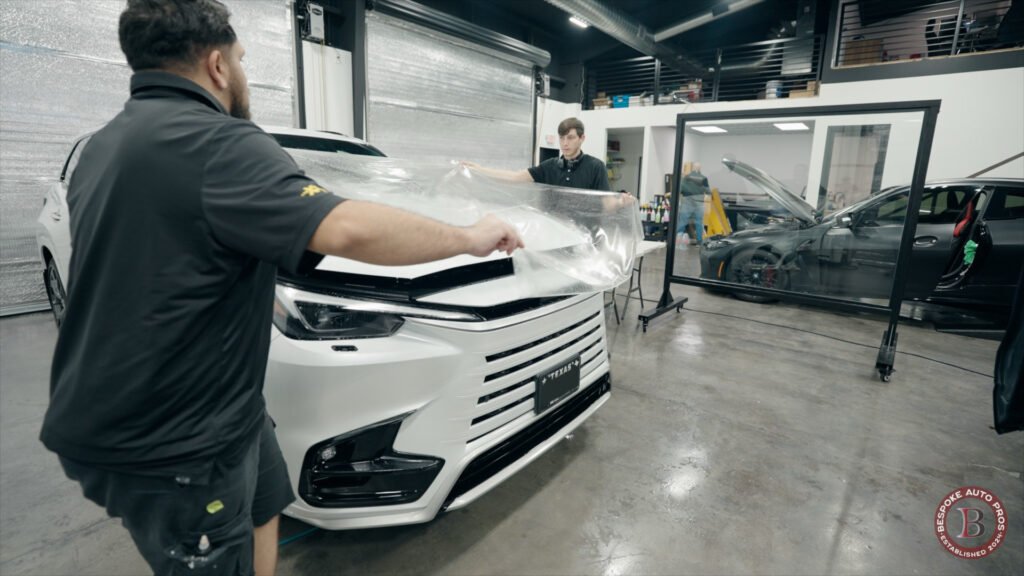 Bespoke Auto Pros technicians applying paint protection film to a vehicle